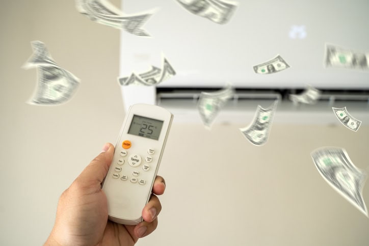 Person adjusting the ac with money coming out of it.